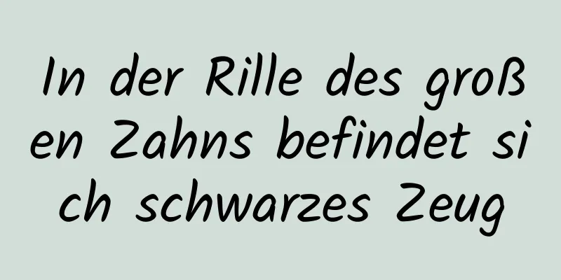 In der Rille des großen Zahns befindet sich schwarzes Zeug